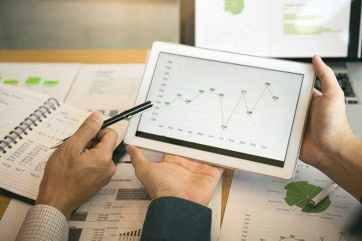 Business partnership coworkers analysis cost work progress and using a tablet to graph company financial budget report and planning for future in office room.